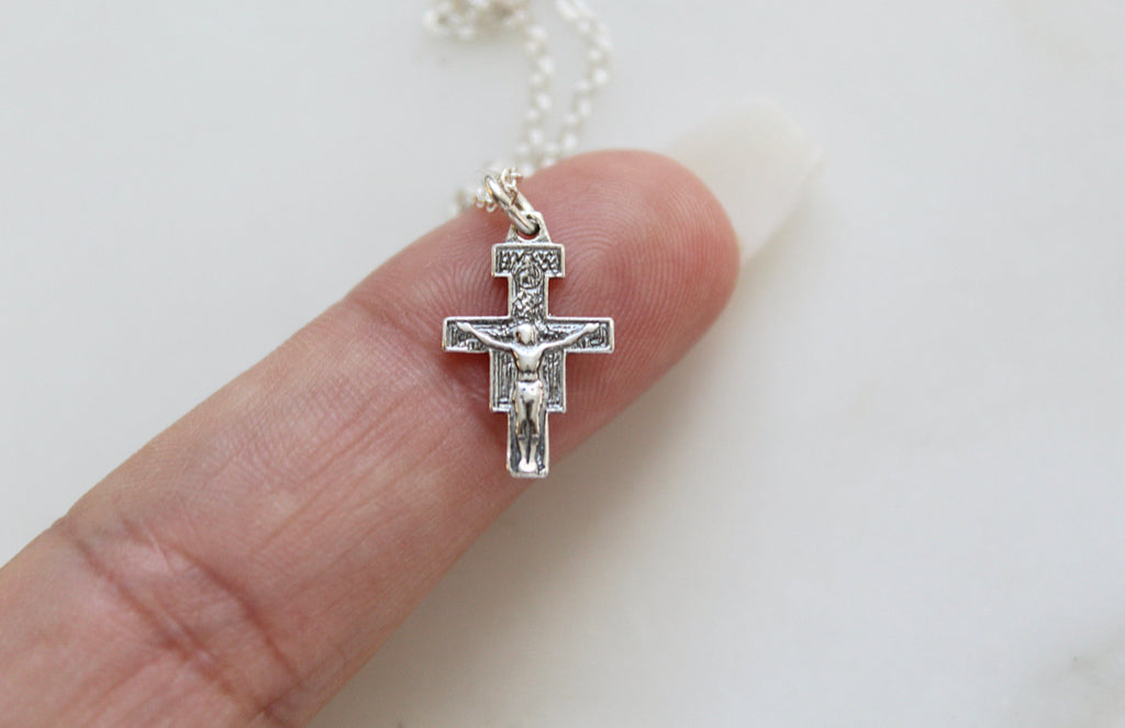 Handmade 925 Sterling Silver San Damiano Crucifix Necklace. The Medal is  5/8" X 3/8". Necklace is Ethically Handmade in Southern California. This is a perfect gift for anyone. The San Damiano Crucifix was inspired by St. Francis. This San Damiano Crucifix necklace comes in several Length and chain styles. One chain stil is a simple flat link chain. The other Chain style is a beautiful tight link chain with tiny perfectly spaced out Balls on it. Both Chain Styles are very popular. 