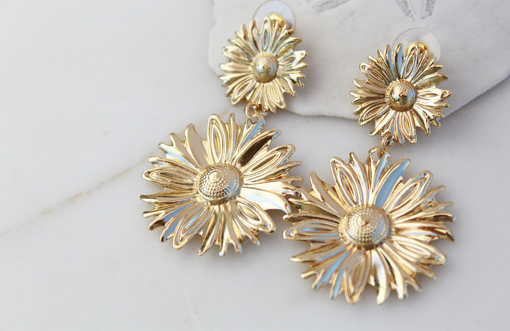 These are 2 tiered Dangle Sunflower Earrings. They're Gold Toned.