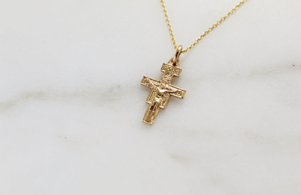 5/8"x3/8" San Damiano Crucifix necklace is played flat. Its yellow 14K Gold.
