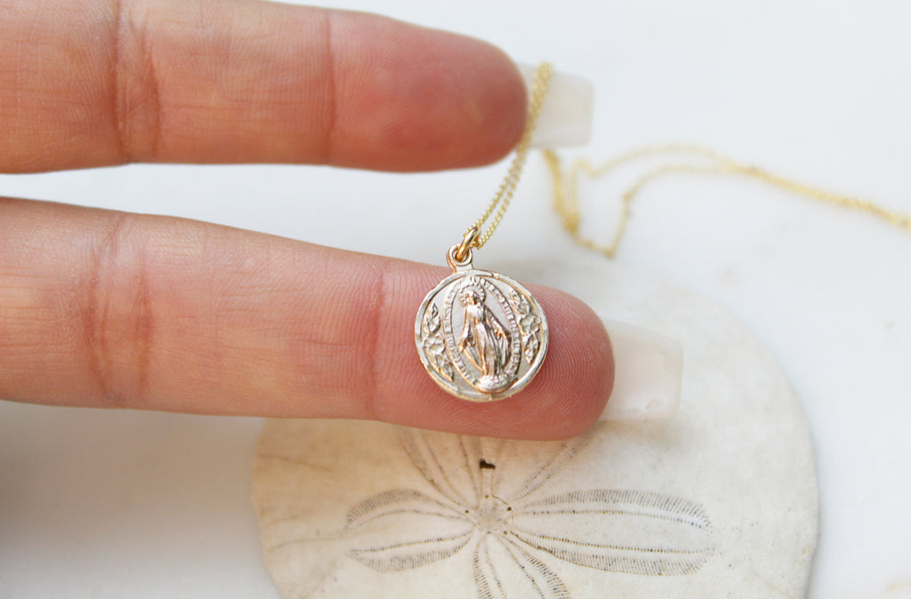Handmade Miraculous Medal Necklace in 14K Gold. Medal is round. Chain is dainty Cable Chain. Medal Size on This Necklace is 5/16" x 1/2". Medal is Beautifully imperfect because it's handmade.