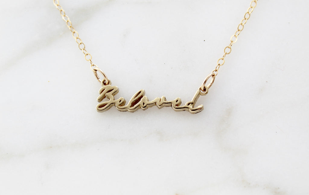 This is our Beloved Necklace in Gold Tone. Medal is Polished Brass. Chain is Gold Filled. . It also comes in a Gold Tone. The "Beloved" Medal is in a handwriting style. Its handmade in Southern California. Chain Style: Simple Dainty Link Chain. Medal Size: 15/16" X 1/8".