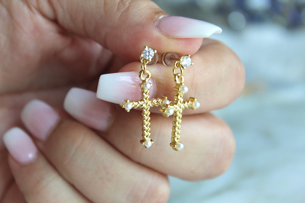 The Cross Earrings are being held to show the Scale