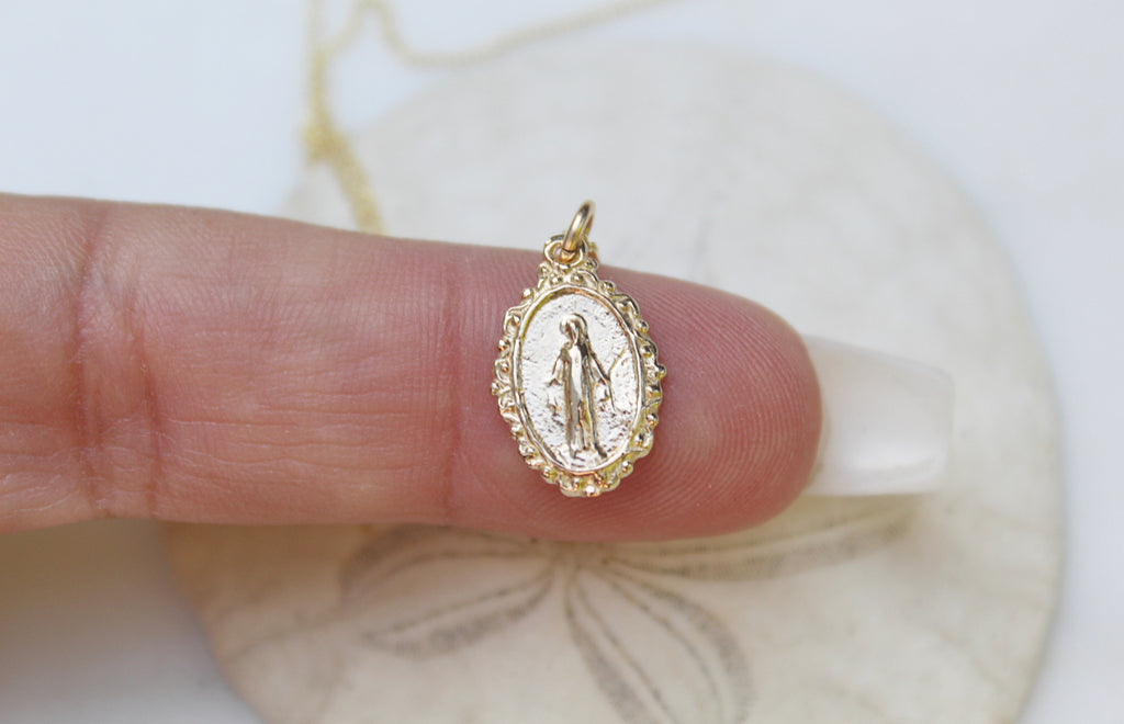 14K Gold Classic Miraculous Medal with the front image of Mary & the back with the traditional Marian cross and 12 stars that represent each disciple. Handmade Medal is 5/8"x3/8". Miraculous Medal is on a 14K Gold Dainty chain.