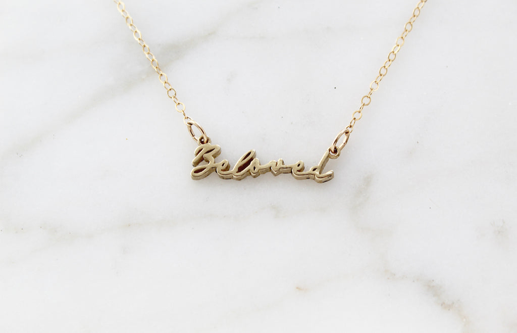 This is our Beloved Necklace in Gold Tone. Medal is Polished Brass. Chain is Gold Filled. . It also comes in a Gold Tone. The "Beloved" Medal is in a handwriting style. Its handmade in Southern California. Chain Style: Simple Dainty Link Chain. Medal Size: 15/16" X 1/8".