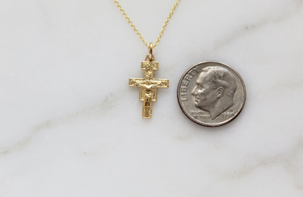 14K Gold San Damiano necklace. Dime is placed next to the San Damiano pendant to show the size. The Size is similar from top to bottom, but not from size to side. Size of medal: 5/8"x3/8"