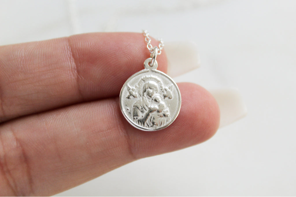 Sterling Silver Our Lady of Perpetual Help Necklace. Medal is handmade in USA. Medal is a circle and is 3/4"X9/16" with the loop in mind. Chain is simple and dainty. Back of Medal is blank. Markings on handmade medal are normal.